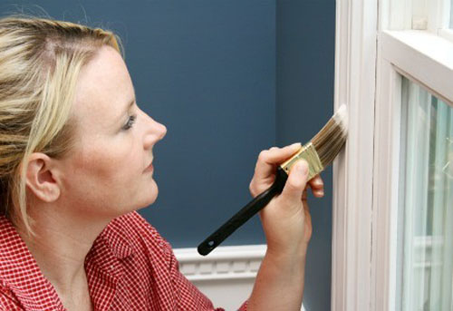 lady glossing a white window frame with alkyd paint