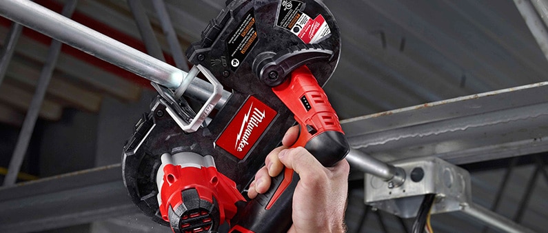 A Man Cutting Metal Pipe With Milwaukee 2429-21XC