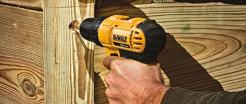 A Man Drilling Hole In The Wood With DeWalt Drill