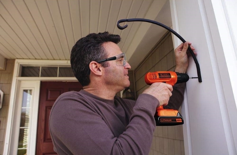 A man working with Black and Decker BDC120VA100 Drill